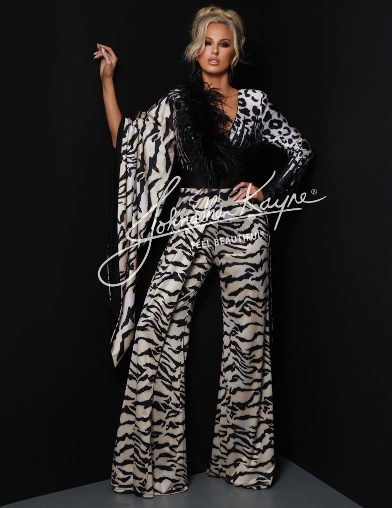 Johnathan Kayne’s Style 2884 is not just a jumpsuit—it’s a moment. Drenched in power and personality, this look channels the bold spirit of the woman who refuses to blend in. With an exotic animal print that prowls across a metallic pleated knit fabric, this piece is as untamed as it is elegant.